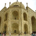 Experience the awe-inspiring beauty of the Taj Mahal, where intricate carvings and stunning architecture captivate all who visit. A detailed view of the Taj Mahal, a stunning white marble mausoleum in Agra, showcasing its central dome and four minarets.