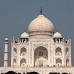 Experience the serenity of the Taj Mahal at sunrise, as seen during a sunrise Taj Mahal tour from Delhi, showcasing its stunning marble architecture and symmetrical beauty. Sunrise view of the Taj Mahal with intricate marble details and symmetrical design, captured during the sunrise Taj Mahal tour from Delhi.